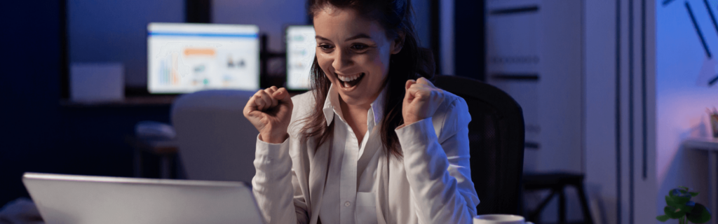 mulher comemorando em frente ao computador
